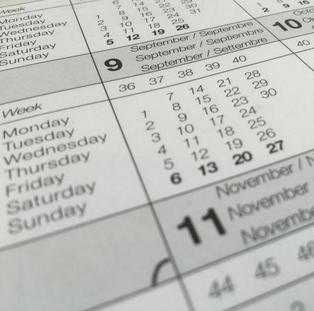 Detailed close-up of a calendar displaying months in several languages.